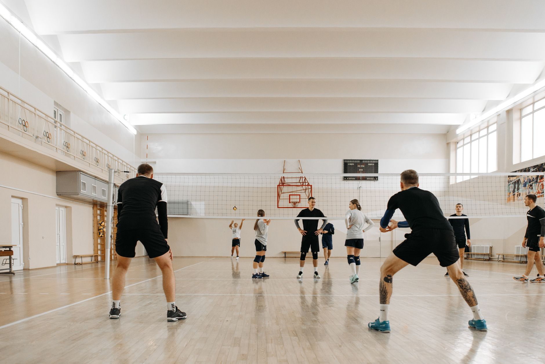 Mecz siatkówki halowej, zawodnicy przy siatce w akcji drużynowej