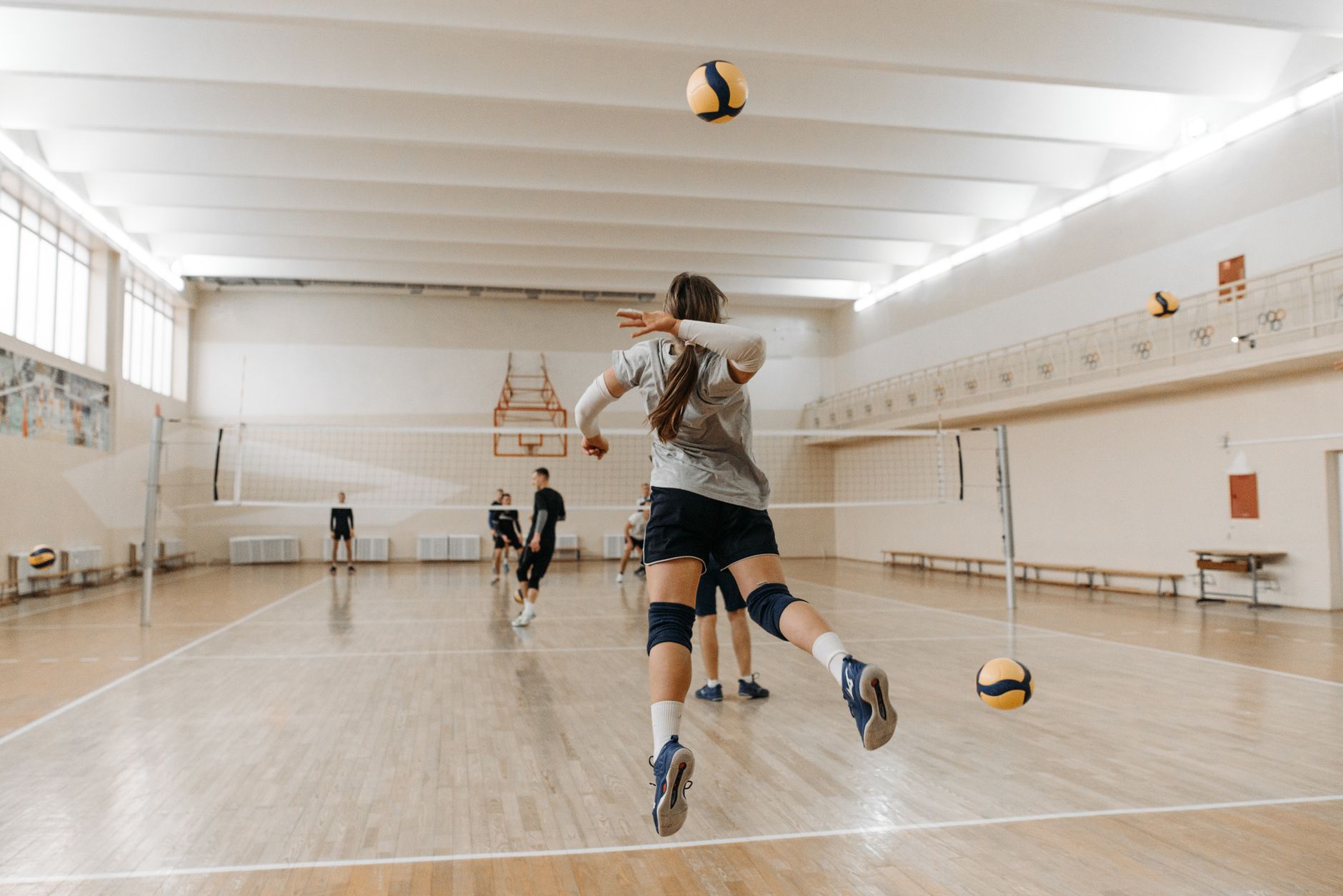 Mecz siatkówki w hali sportowej z zawodnikami w dynamicznej akcji