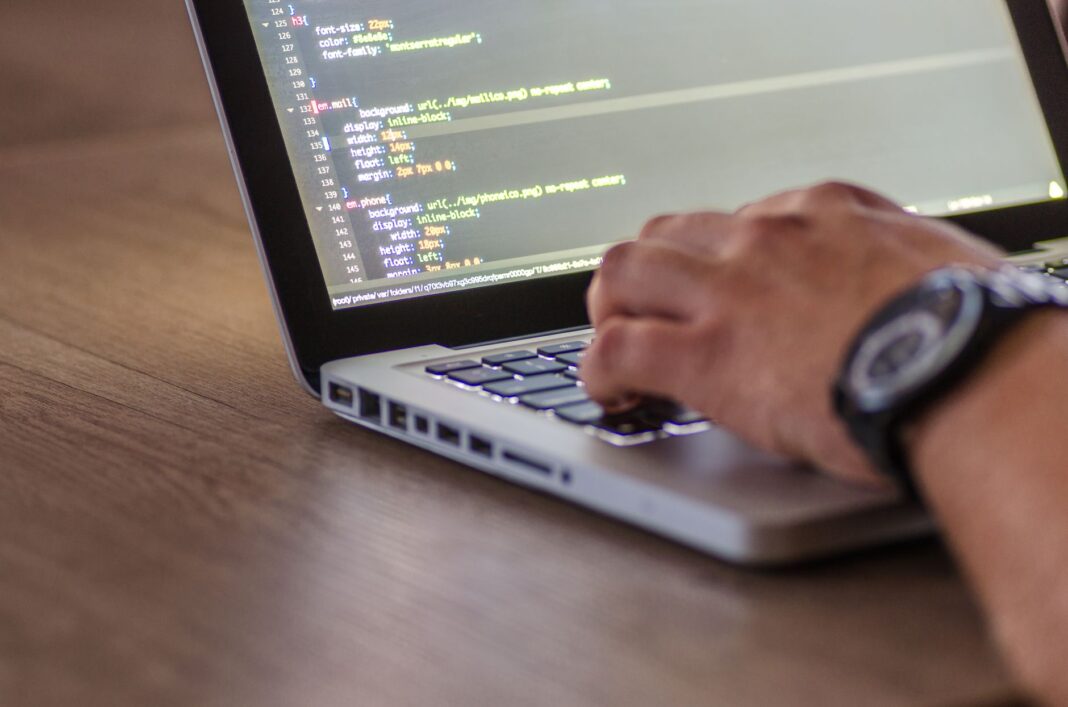 Programista piszący kod DevOps na laptopie z widocznym ekranem Programista piszący kod DevOps na laptopie z widocznym ekranem
