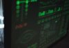 Zbliżenie monitora z zielonymi wykresami bezpieczeństwa i wydajności systemu