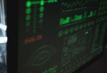 Zbliżenie monitora z zielonymi wykresami bezpieczeństwa i wydajności systemu