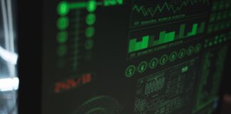 Zbliżenie monitora z zielonymi wykresami bezpieczeństwa i wydajności systemu