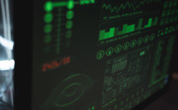 Od logów do metryk: pełny przewodnik po obserwowalności wydajności systemów Zbliżenie monitora z zielonymi wykresami bezpieczeństwa i wydajności systemu