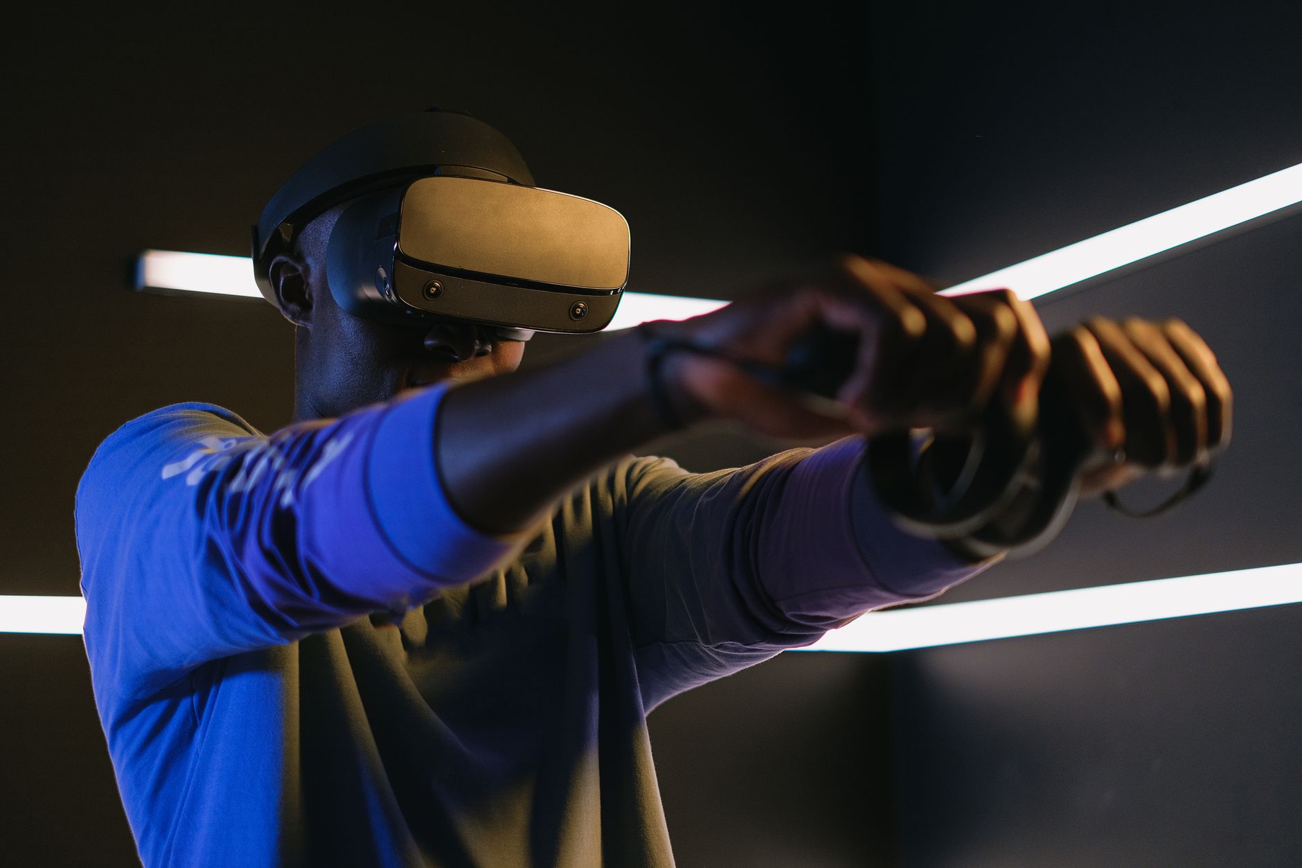 Gracz w goglach VR z kontrolerami w futurystycznym pokoju