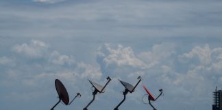 Internet satelitarny w Polsce – dla kogo ma sens, a kiedy lepszy jest światłowód Cztery anteny satelitarne na dachu pod pochmurnym niebem