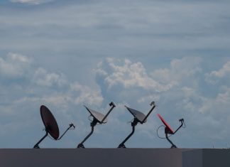 Internet satelitarny w Polsce – dla kogo ma sens, a kiedy lepszy jest światłowód Cztery anteny satelitarne na dachu pod pochmurnym niebem