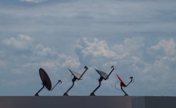 Internet satelitarny w Polsce – dla kogo ma sens, a kiedy lepszy jest światłowód Cztery anteny satelitarne na dachu pod pochmurnym niebem