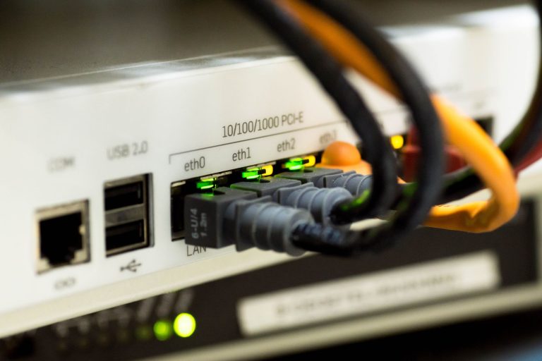 Kable Ethernet podłączone do portów routera sieciowego